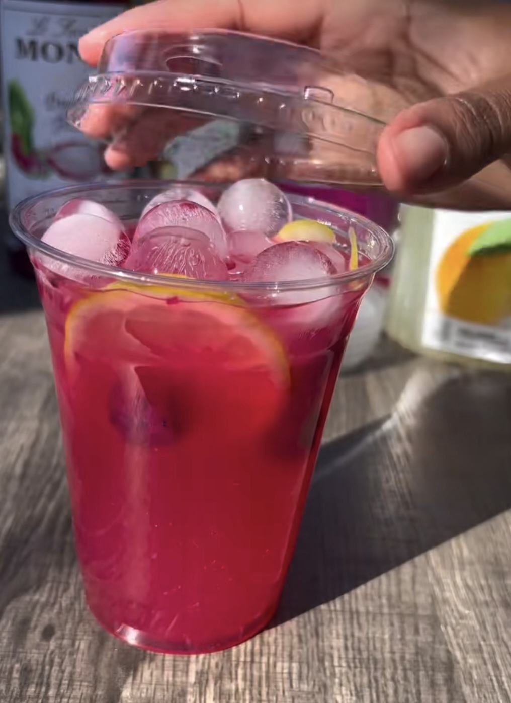 Drink rosa com gelo e frutas sendo lacrado